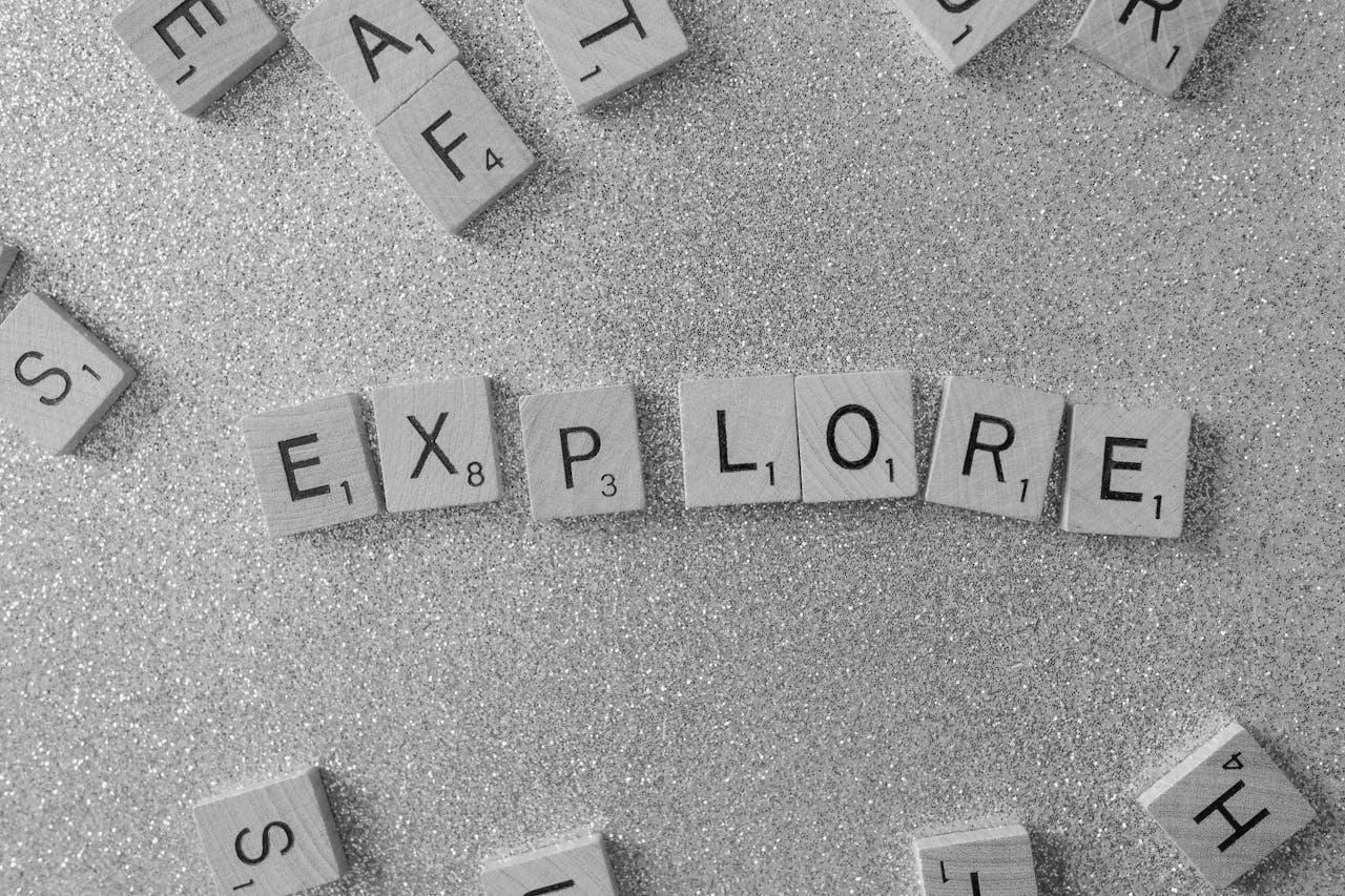our-services-3 Ambient shot of Scrabble tiles spelling 'Explore' on a glittery surface.